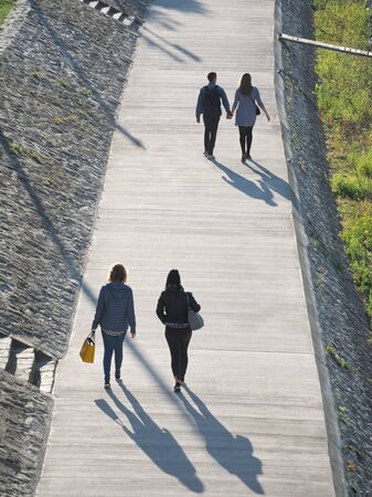 People Walking on Riverside Promenade on a Sunny Autumn Day in GyÅr, Hungaryの写真素材