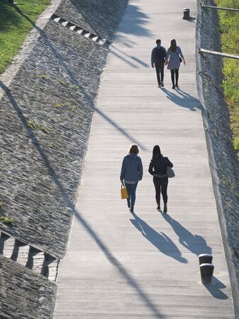People Walking on Riverside Promenade on a Sunny Autumn Day in GyÅr, Hungaryの写真素材