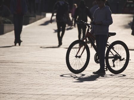 Backlit Boy with Bicycle on the Street on a Sunny Autumn Afternoonのeditorial素材