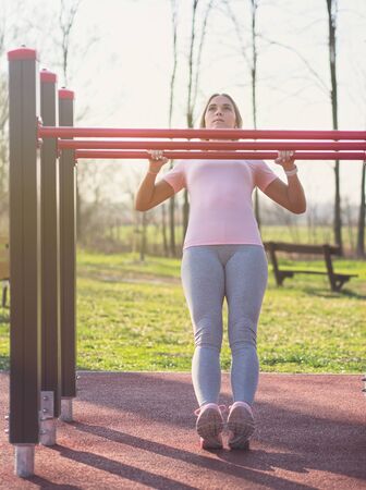 Young Woman Doing Australian Pull Ups in the Park
