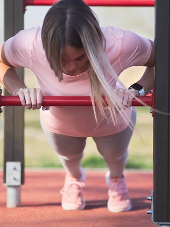 Young Woman Doing Push Ups in the Park Closeup