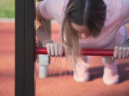 Young Woman Doing Push Ups in the Park Closeup