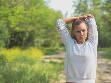 Young Blonde Caucasian Female Forest Runner Stretchingの写真素材