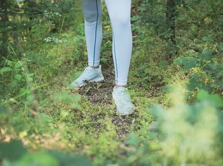 Female Runner in Sportswear Standing in Dense Forest Closeup on Legs