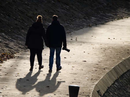 Silhouette of a Middle Aged Pair on a Walk with Cameraの写真素材