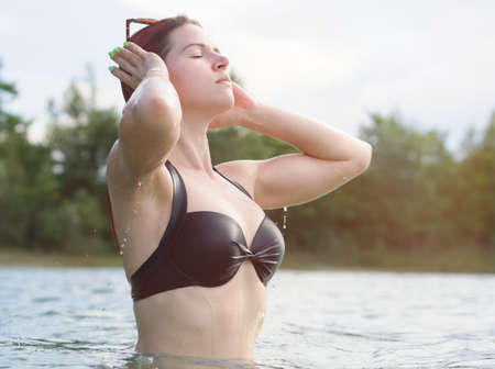 Young Woman with Red Hair Emerging from Waterの写真素材