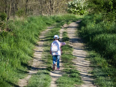 Little Girl Running away on a Dirt Roadの写真素材