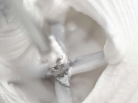 Hand Mixer Blades in White Whipped Cream Macro Closeupの写真素材