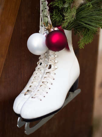 White Ice Skates Hanging on Wood Fence with Christmas Decoration
