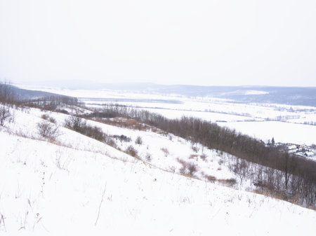 Winter landscape. Snow-covered field and village on the horizon.の写真素材
