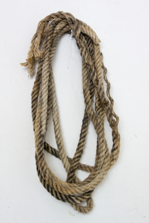 Skein of thick braided rope hanging on a white wallの写真素材