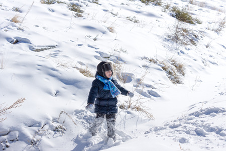 Little boy playing in the snow. Doth sing and rejoiceの写真素材