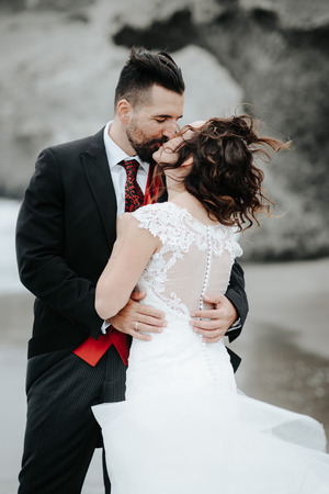 The bride and groom are walking along the beach. Panoramic view. Hugging.の写真素材