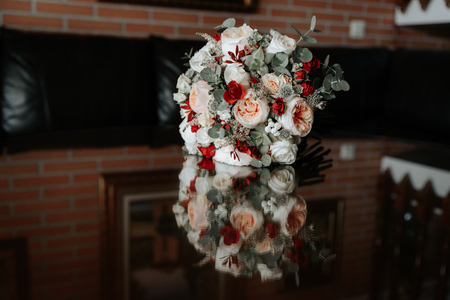 Bridal bouquet. Reflection of a wedding bouquet in glass, mirror. Flowers lie on the table.の写真素材