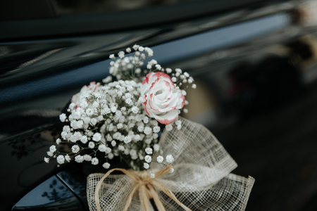 Door of black wedding car decorated with bouquet and white bow. Wedding bouquet carの写真素材