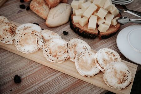 Tasting cheese dish on a wooden plate. Food for wine and romantic, cheese delicatessen on a wooden rustic table. Top viewの写真素材