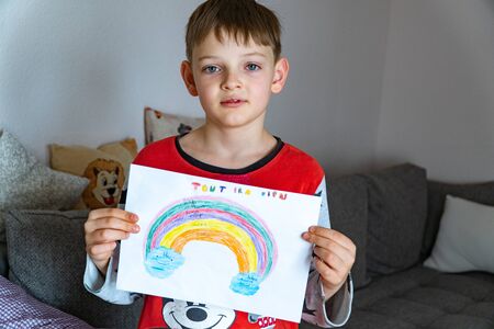 A cute boy with a painted rainbow with EVERYTHING WILL BE GOOD in French, asks for the prevention of...
