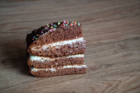Chocolate Cake. Piece of Cake on a Plate. Sweet food. Sweet dessert. Wooden background. On a wooden...