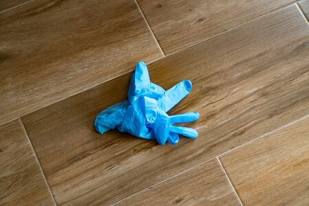 COVID-19 Coronavirus Infection control concept. Discarded lying on the floor blue disposable gloves...