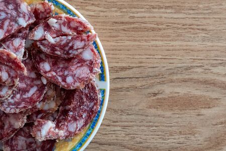 Slices of red spanish sausage called fuet on a spanish style plateの写真素材