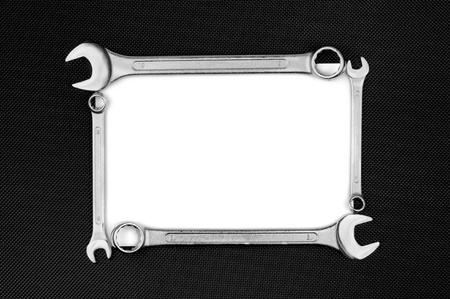 Blank card with wrenches on the black dotted metal plate.の写真素材