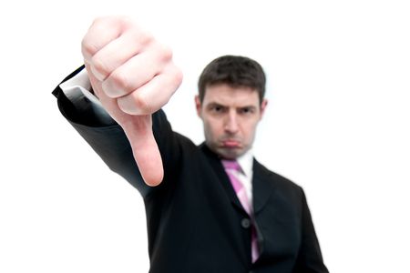 A mid thirties businessman in a black suit indicates THUMBS DOWN with his hand.  Differential focus...