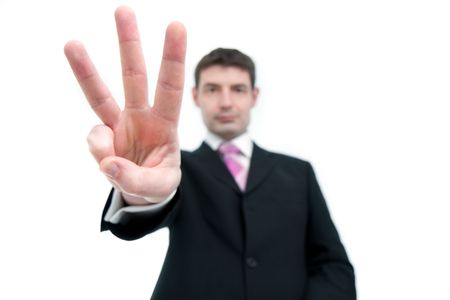 A mid thirties businessman in a black suit holding up three fingers.  Differential focus on the hand.の写真素材
