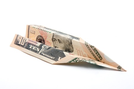 A US ten dollar bill folded up into a paper airplane.  Studio isolated on a white background.の写真素材