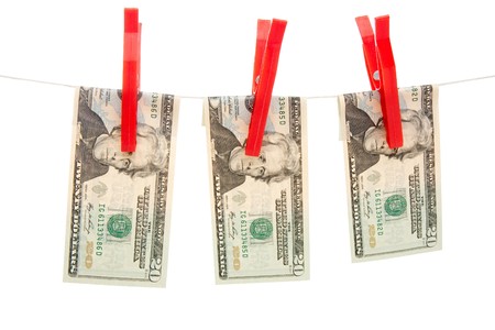 Three US twenty dollar bills pegged to a line with three red clothes pegs.