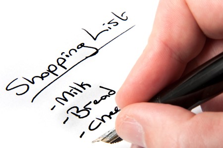A male hand writing a shopping listの写真素材