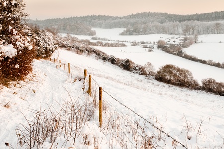 A view over some snow covered fields at dusk.  Taken on Pewley Down in Guildford, Surrey on a snowy December evening.の写真素材