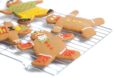 Some freshly baked home made gingerbread men on a wire cooling rack.  Differential focus on the face...