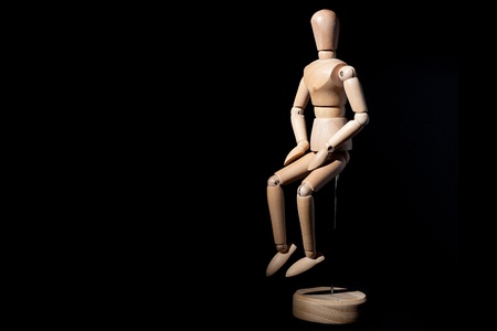 A wooden mannequin on a black background.の写真素材