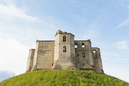 The ruins of an English castle sit on the top of a mound of grass.のeditorial素材