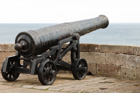 An old canon faces out to sea on a battlement wall in an English castle.の写真素材