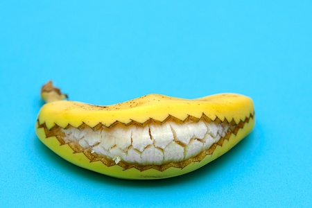 A banana cut and opened so that it looks like a smiling mouth with teeth の写真素材
