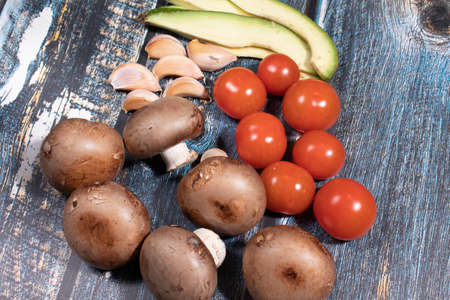 Fresh vegetables tomatoes mushrooms garlic and avocadoの写真素材
