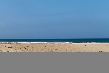 Waves, beach, ocean and blue sky shot at sunny day. Travel paradise for relaxation.