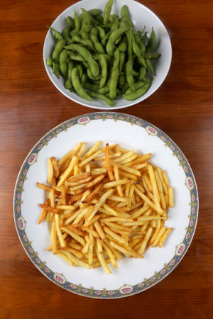 fresh cooked edamames and fried potatoes as side dishの写真素材