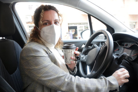 woman drinking coffee in the car as a driver