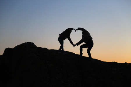silhouettes of people in the mountain with sunrise sky background