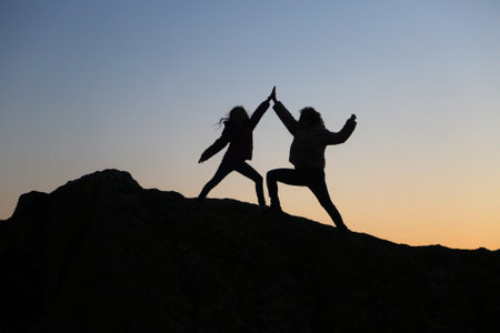 silhouettes of people in the mountain with sunrise sky backgroundの写真素材