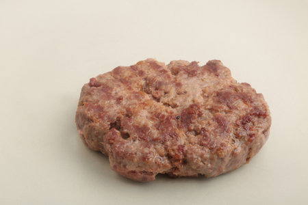 Raw hamburger patty on a white background, closeup of photoの写真素材