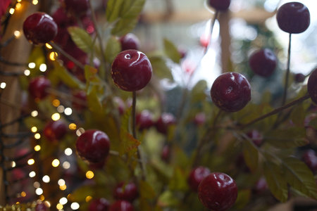 Cherries with Christmas lights on the background. Selective focus.