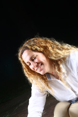 Portrait of a beautiful young woman with curly hair on a black background