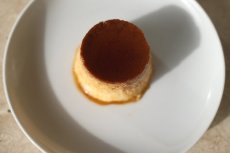 Creamy caramel pudding on a white plate, close-upの写真素材