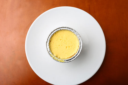 Creme brulee in a bowl on a wooden table.の写真素材