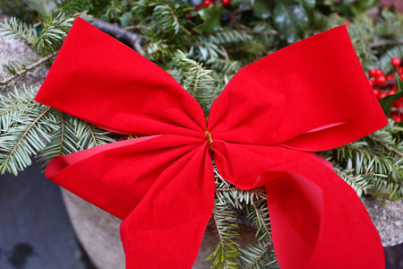 Christmas decoration with red bow on spruce branches, close-upの写真素材