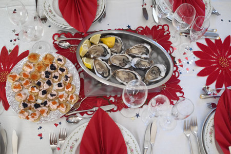 Festive table setting with fresh oysters, lemon and cutleryの写真素材