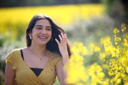 Portrait of a beautiful young woman in a field of yellow flowersの写真素材